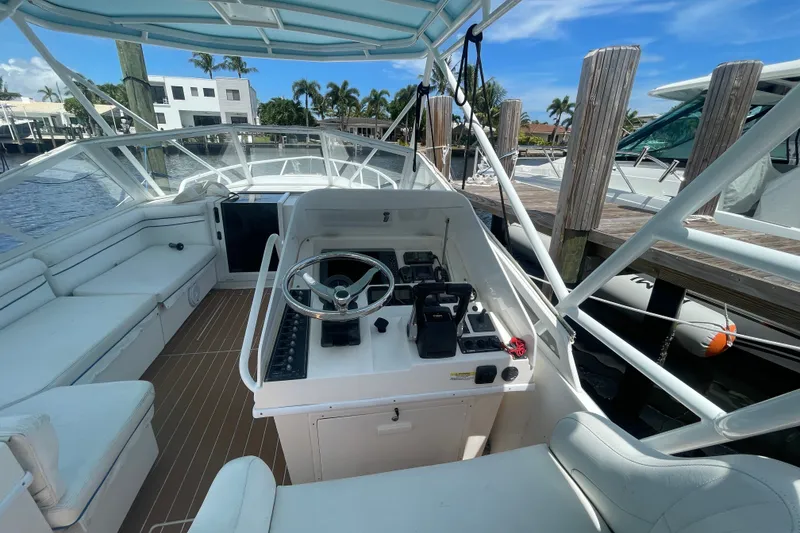 Slide: The Image of 2007 Contender 35 Side Console boat interior with steering wheel and seating, docked by the water. - 5