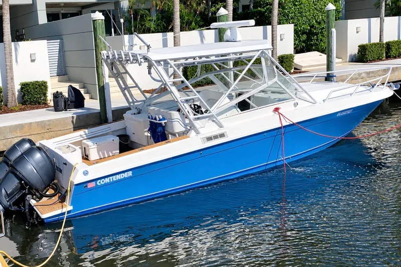 The Image of 2007 Contender 35 Side Console boat docked, featuring a sleek blue and white design. - 0