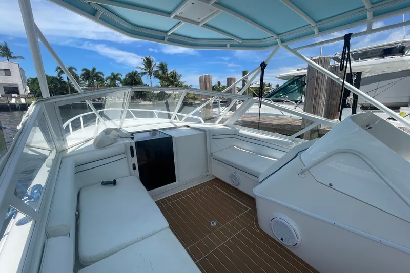 Slide: The Image of 2007 Contender 35 Side Console boat interior with white seating and blue canopy. - 2