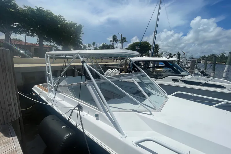 Slide: The Image of 2007 Contender 35 Side Console boat docked at marina under clear blue sky. - 17