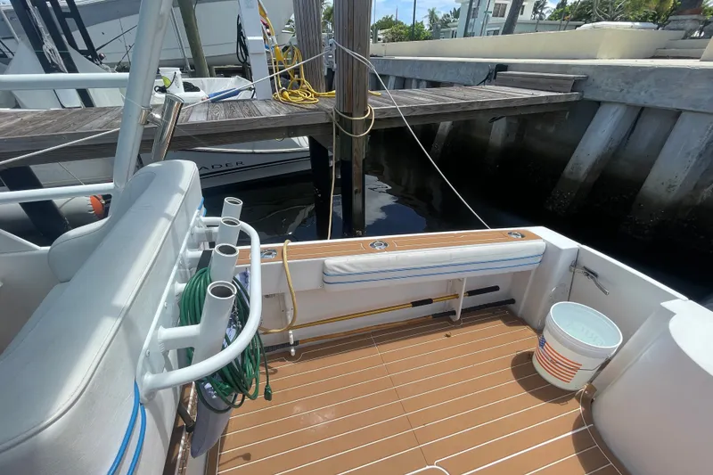 Slide: The Image of 2007 Contender 35 Side Console boat docked, featuring rod holders and deck equipment. - 8