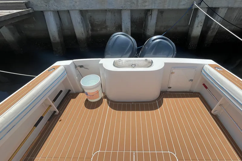 Slide: The Image of 2007 Contender 35 Side Console boat deck with twin engines and teak flooring. - 9