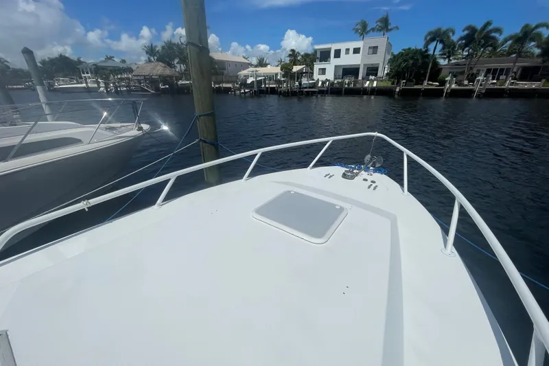 Slide: The Image of 2007 Contender 35 Side Console boat docked by waterfront homes under a clear blue sky. - 16