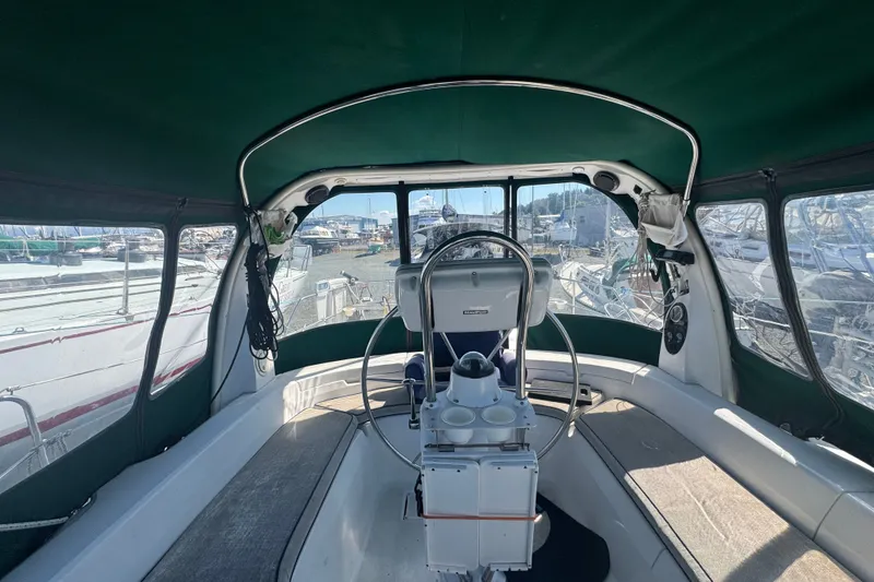Slide: The Image of Interior view of a 1999 Hunter 420 sailboat cockpit with green canopy and steering wheel. - 5
