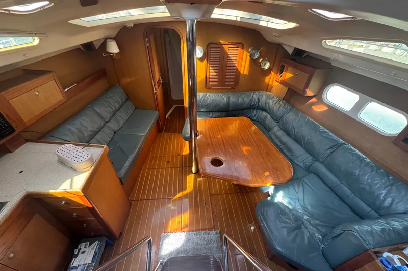 Slide: The Image of Interior of a 1999 Hunter 420 sailboat with wood finish and blue seating. - 24