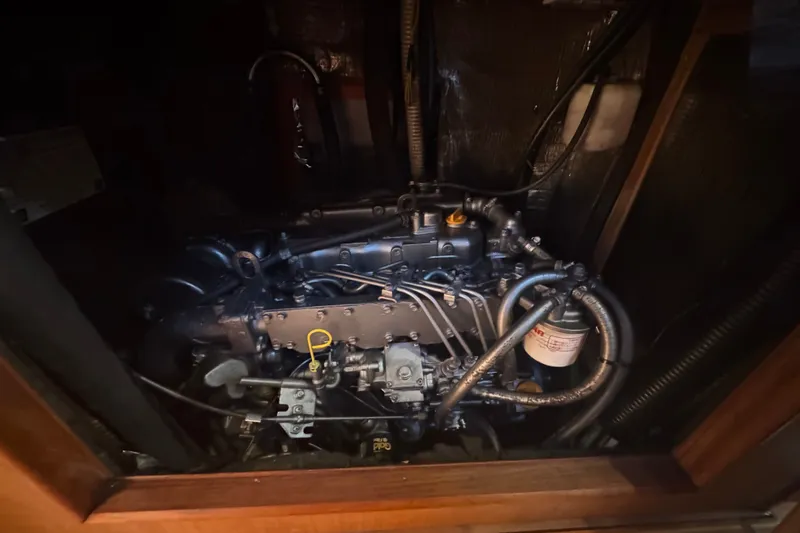 Slide: The Image of Engine compartment of a 1999 Hunter 420 sailboat, showcasing intricate mechanical components. - 22