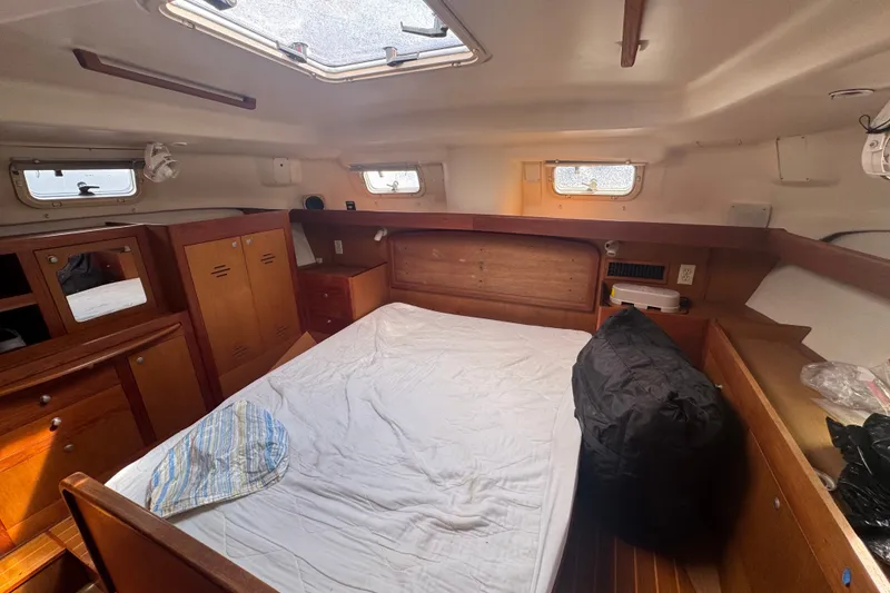Slide: The Image of Interior cabin of a 1999 Hunter 420 sailboat with wooden furnishings and a bed. - 19