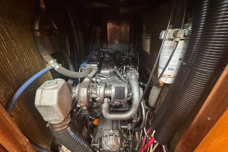 Slide: The Image of Engine compartment of a 1999 Hunter 420 sailboat, showcasing mechanical components and hoses. - 23