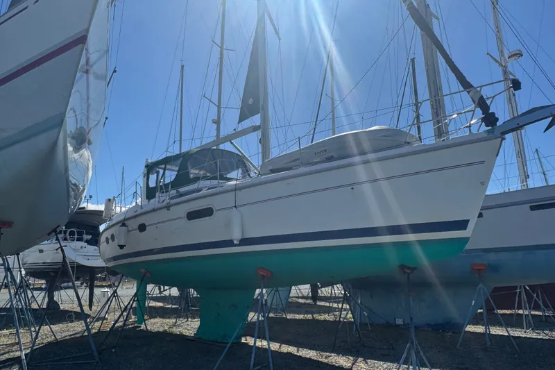 The Image of 1999 Hunter 420 sailboat on stands, sunlit, with blue and white hull. - 0