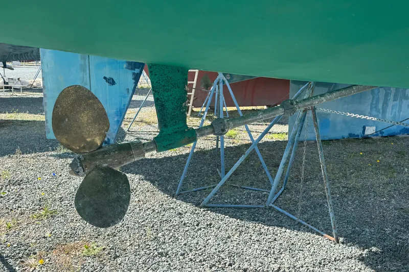 Slide: The Image of Propeller and rudder of a 1999 Hunter 420 sailboat on a gravel surface. - 32