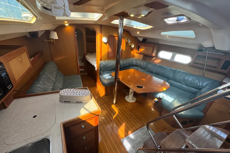 Slide: The Image of Interior of a 1999 Hunter 420 sailboat with cozy seating and wooden finishes. - 14