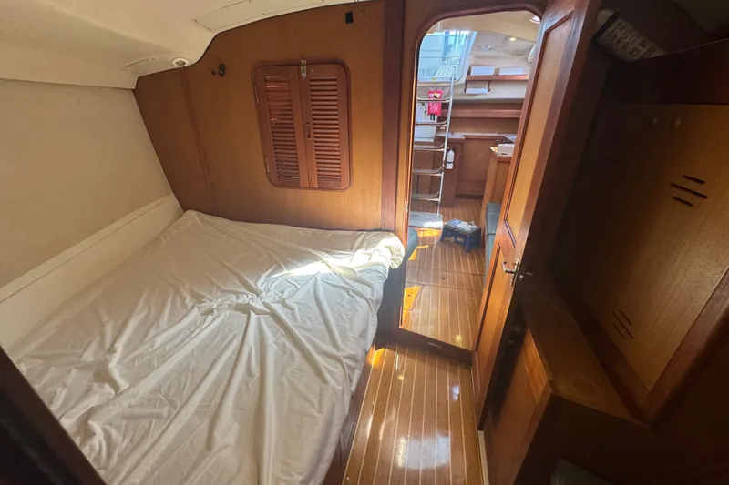 Slide: The Image of Interior cabin of a 1999 Hunter 420 sailboat with wooden finishes and a cozy bed. - 9