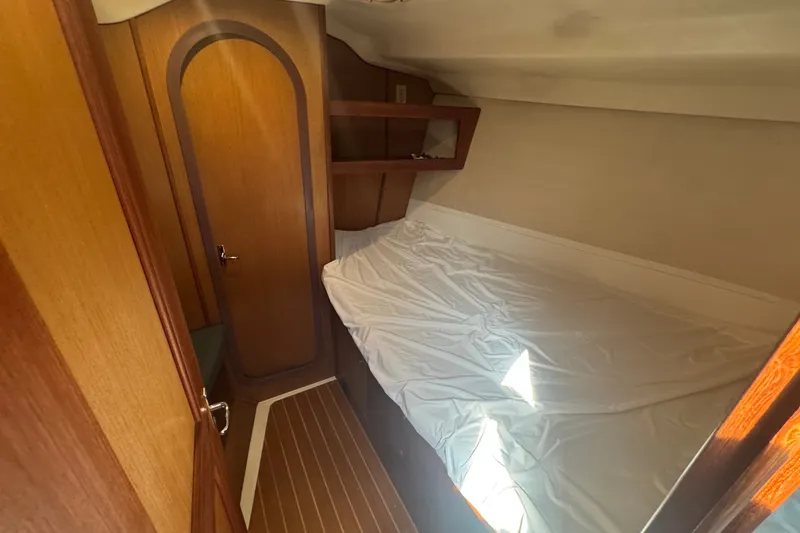 Slide: The Image of Cozy cabin interior of 1999 Hunter 420 sailboat with wooden finishes and bed. - 7