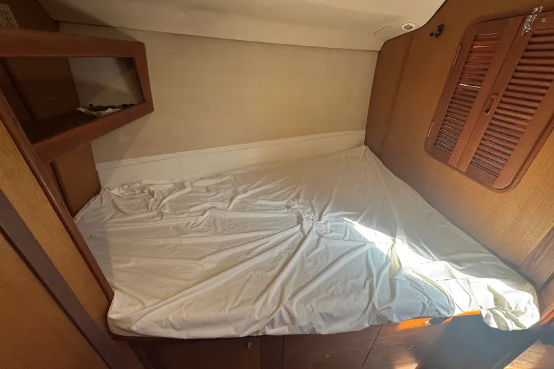 Slide: The Image of Cozy cabin interior of 1999 Hunter 420 sailboat with wooden accents and bed. - 6