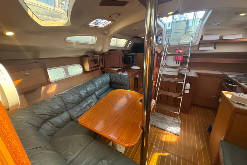 Slide: The Image of Interior of a 1999 Hunter 420 sailboat with cozy seating and wooden finishes. - 11