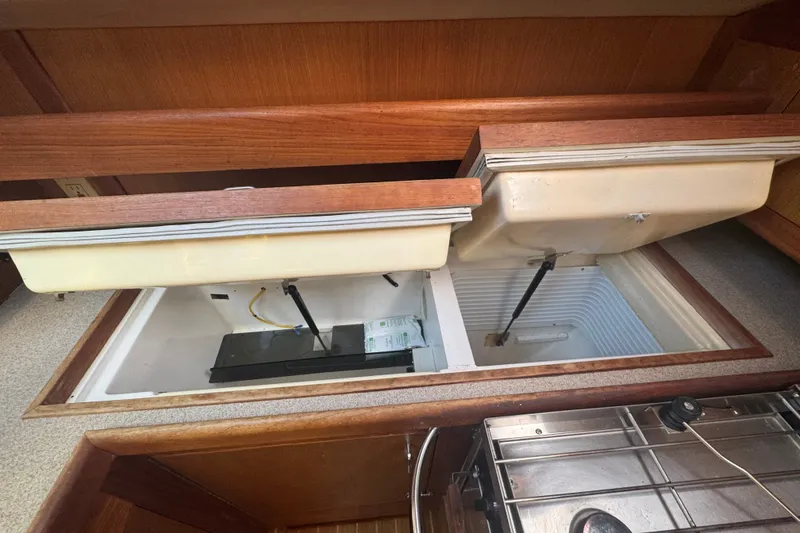 Slide: The Image of Interior view of a 1999 Hunter 420 sailboat's storage compartments and kitchen area. - 13