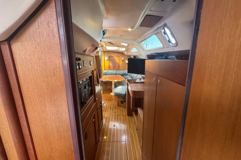 Slide: The Image of Interior of a 1999 Hunter 420 sailboat with wood paneling and seating area. - 21