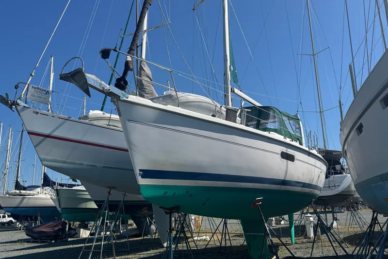 Slide: The Image of Sailboats in a marina, featuring a 1999 Hunter 420 model on stands. - 2