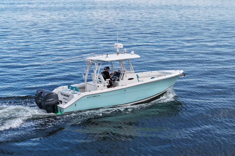 The Image of 2015 Cobia 296 Center Console boat cruising on open water. - 1