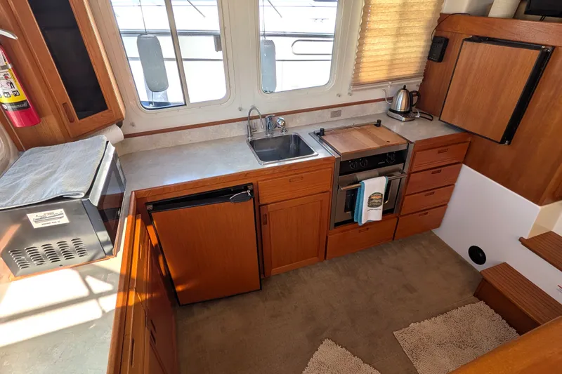 Slide: The Image of Interior of 2010 Nordic Tug 32 galley with wooden cabinetry and modern appliances. - 17