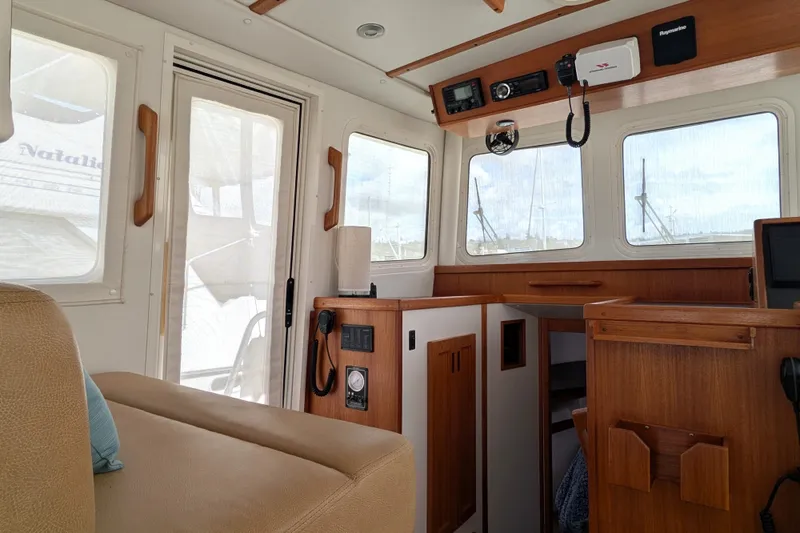 Slide: The Image of Interior of a 2010 Nordic Tug 32, featuring wood accents and navigation equipment. - 23