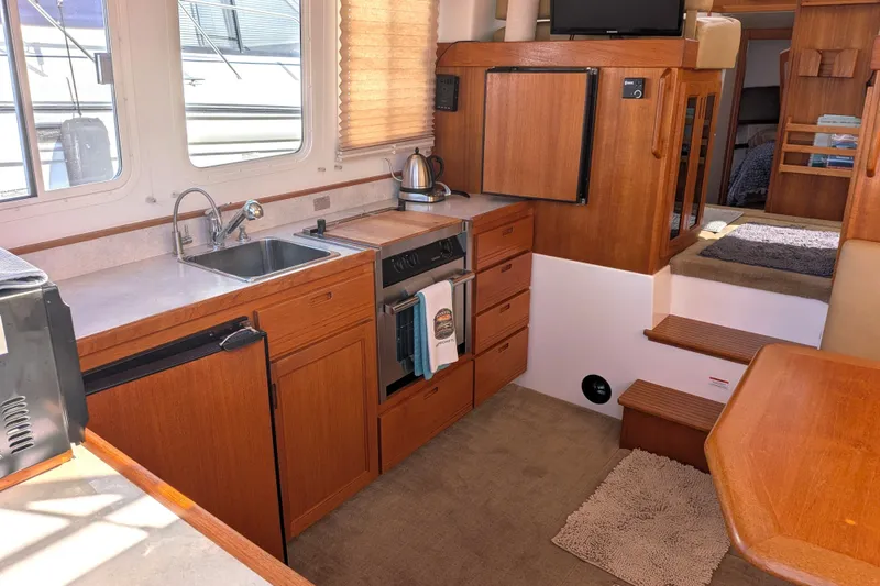 Slide: The Image of Cozy interior of a 2010 Nordic Tug 32 with a well-equipped kitchen area. - 14