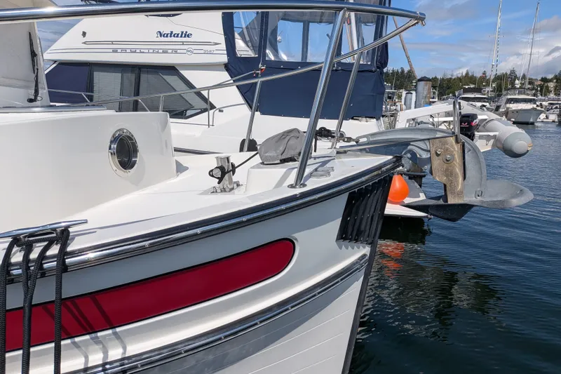 Slide: The Image of 2010 Nordic Tug 32 docked at marina, featuring sleek design and anchor detail. - 6