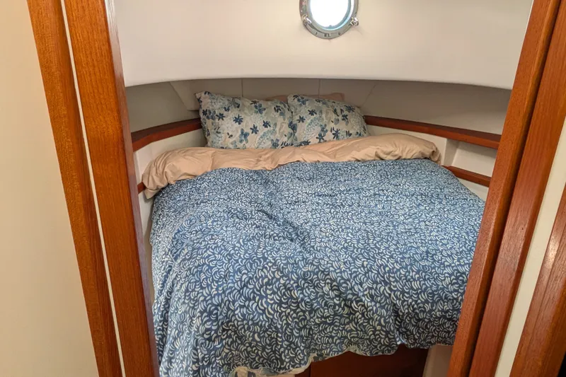 Slide: The Image of Cozy cabin bedroom in 2010 Nordic Tug 32 with floral bedding and wooden accents. - 38