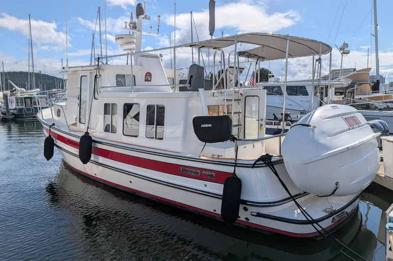 Slide: The Image of 2010 Nordic Tug 32 docked at marina, featuring classic design and spacious deck. - 3