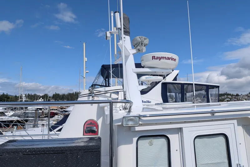 Slide: The Image of 2010 Nordic Tug 32 with Raymarine equipment docked under a clear blue sky. - 8