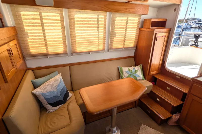 Slide: The Image of Cozy interior of 2010 Nordic Tug 32 with beige seating, wooden table, and nautical decor. - 18