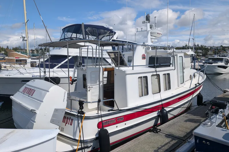 Slide: The Image of 2010 Nordic Tug 32 docked at marina, featuring classic design and spacious deck. - 2