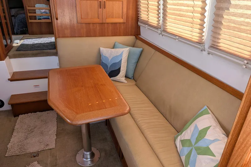 Slide: The Image of Cozy interior of 2010 Nordic Tug 32 with cushioned seating and wooden table. - 15