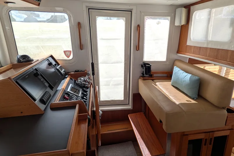 Slide: The Image of Interior of a 2010 Nordic Tug 32, featuring helm and seating area. - 34