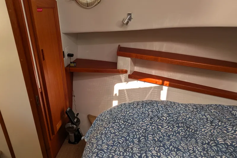 Slide: The Image of Cozy cabin interior of 2010 Nordic Tug 32 with wooden shelves and patterned bedding. - 39