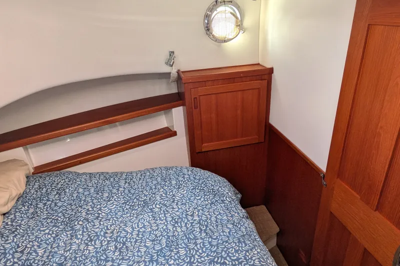 Slide: The Image of Cozy cabin interior of 2010 Nordic Tug 32 with wooden accents and patterned bedding. - 40