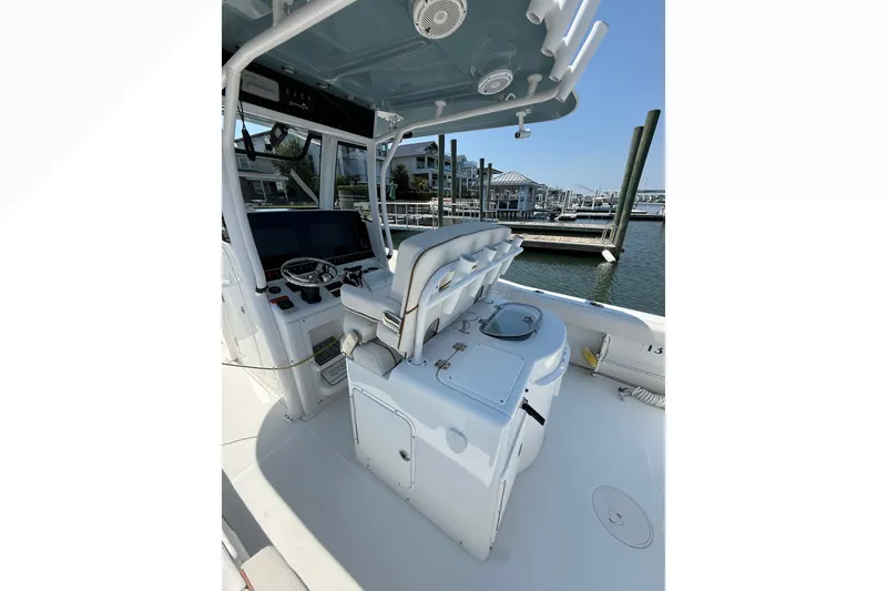 Slide: The Image of 2021 Sea Hunt Gamefish 30FS boat interior with helm, seating, and marina view. - 23