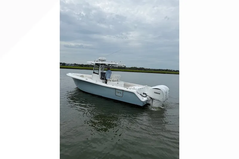 Slide: The Image of 2021 Sea Hunt Gamefish 30FS boat on calm water, featuring Yamaha engines. - 9