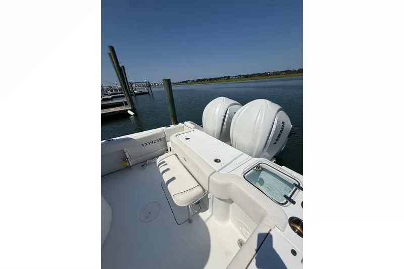 Slide: The Image of 2021 Sea Hunt Gamefish 30FS boat with twin Yamaha engines docked by the water. - 24