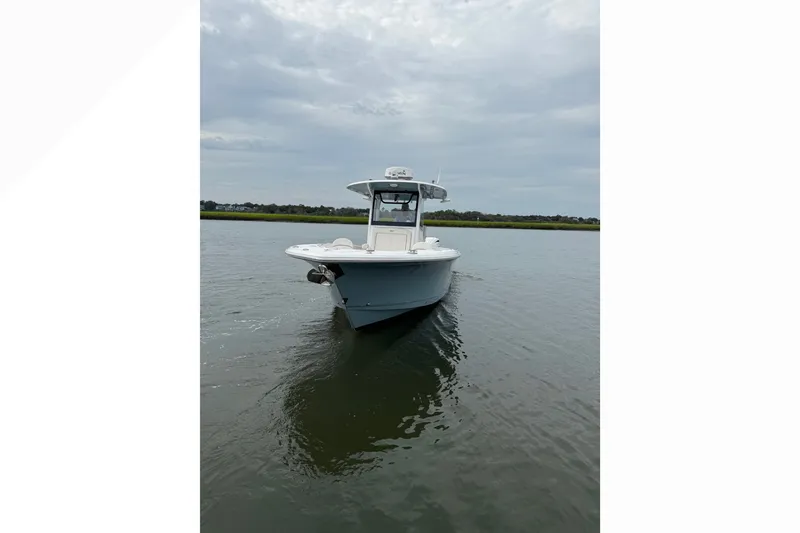 Slide: The Image of 2021 Sea Hunt Gamefish 30FS boat on calm water under cloudy sky. - 3