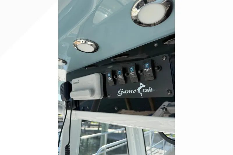 Slide: The Image of 2021 Sea Hunt Gamefish 30FS boat control panel with switches and microphone. - 10