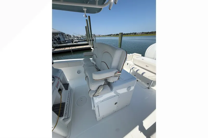 Slide: The Image of 2021 Sea Hunt Gamefish 30FS boat interior with seating, docked by calm waters. - 22