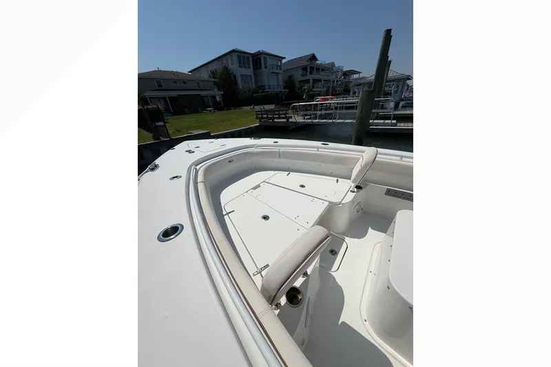 Slide: The Image of 2021 Sea Hunt Gamefish 30FS boat interior with seating, docked near waterfront homes. - 21