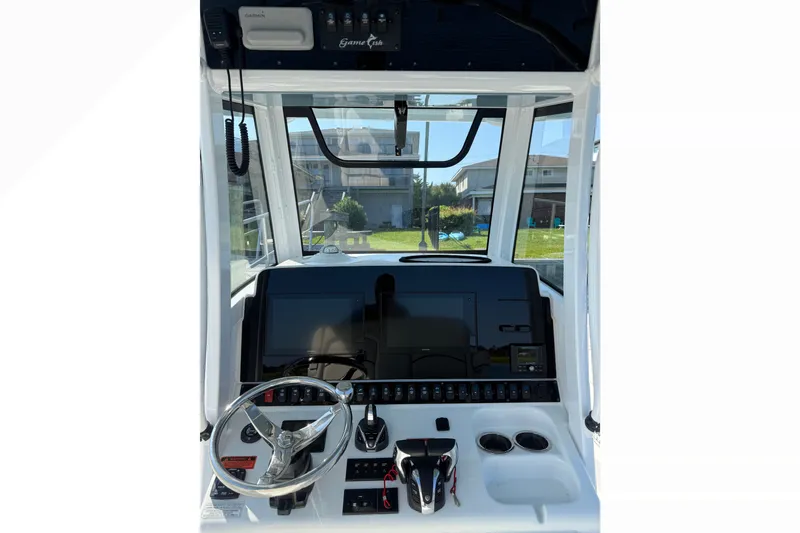 Slide: The Image of 2021 Sea Hunt Gamefish 30FS helm with steering wheel, controls, and navigation display. - 6