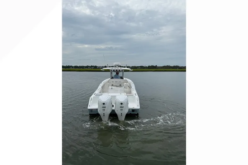 Slide: The Image of 2021 Sea Hunt Gamefish 30FS boat on calm water, rear view with twin engines. - 0