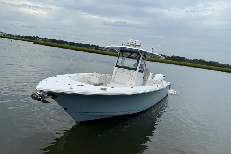 Slide: The Image of 2021 Sea Hunt Gamefish 30FS boat on calm water under cloudy sky. - 4