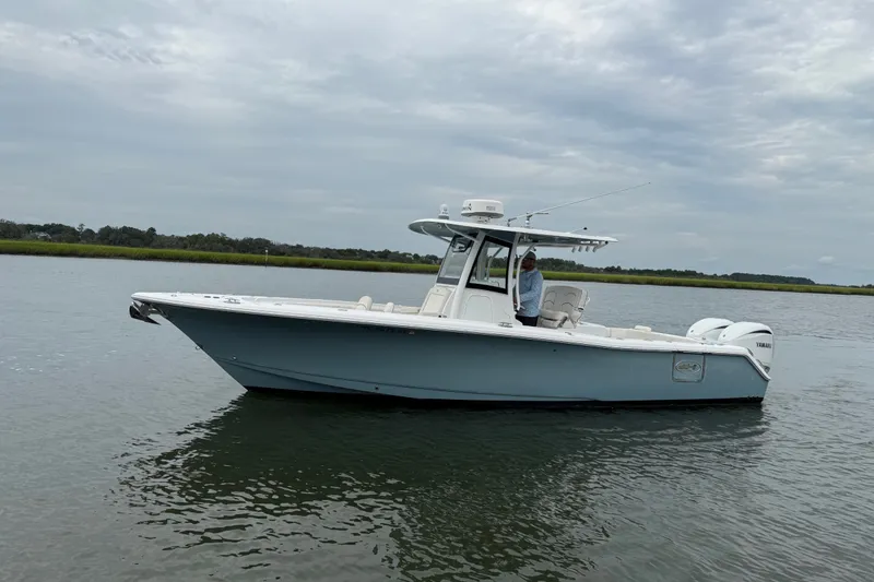 Slide: The Image of 2021 Sea Hunt Gamefish 30FS boat on calm water under cloudy sky. - 2
