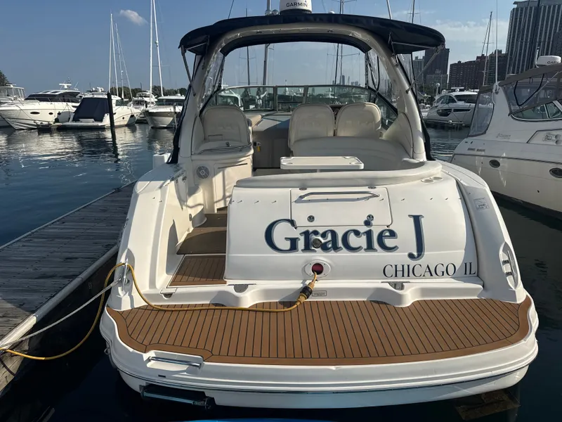Slide: The Image of A 2003 Sea Ray 340 Sundancer docked at a marina. The name "Gracie J" is visible on the stern. - 3