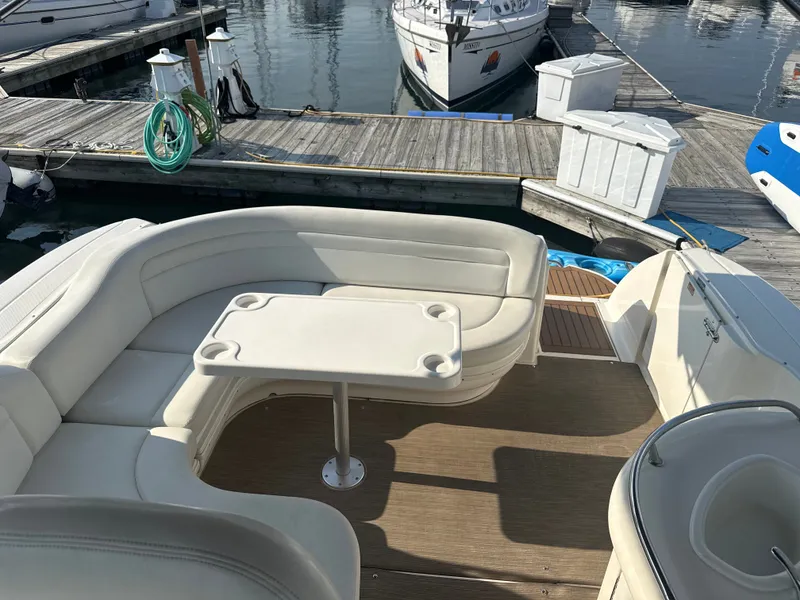 Slide: The Image of The image shows the cockpit of a 2003 Sea Ray 340 Sundancer with white seating and a table. - 6
