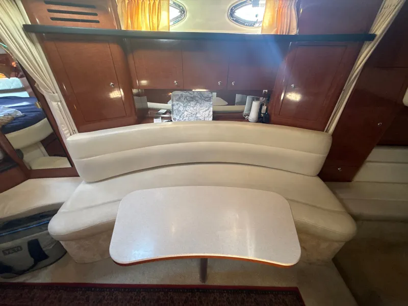 Slide: The Image of Interior of a 2003 Sea Ray 340 Sundancer with a curved sofa and table. - 23